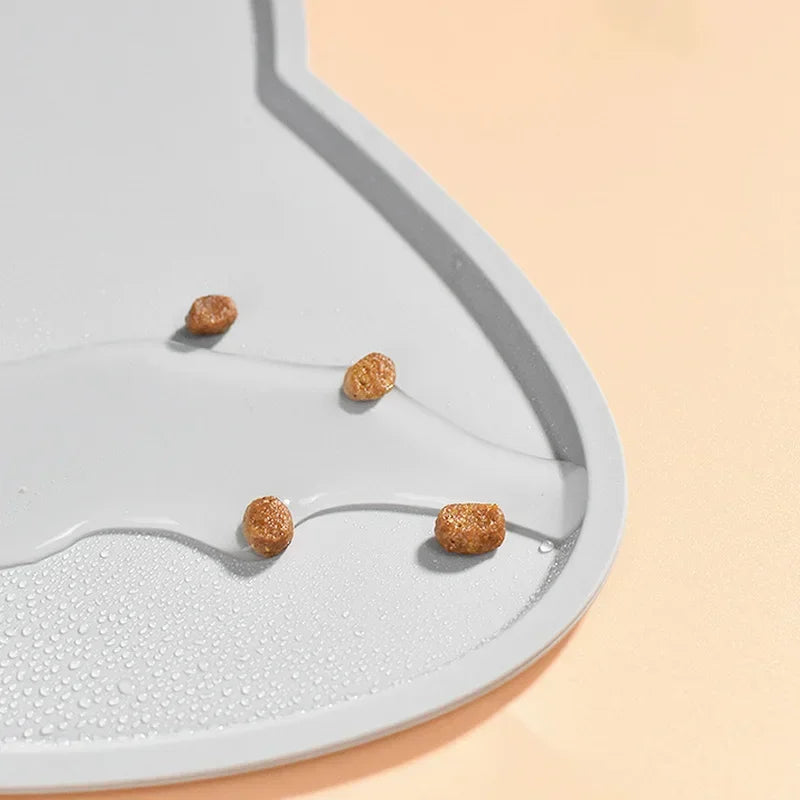 Gray silicone pet feeder with kibble and water droplets, ideal for messy eaters