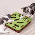Two cats playing with green interactive puzzle feeder toy on striped rug